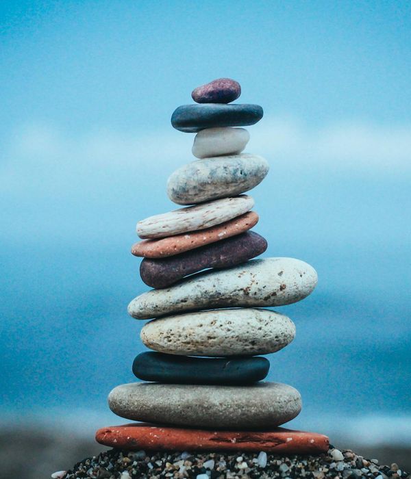 A balanced stack of stones on a wooden surface, symbolizing harmony and stability.
