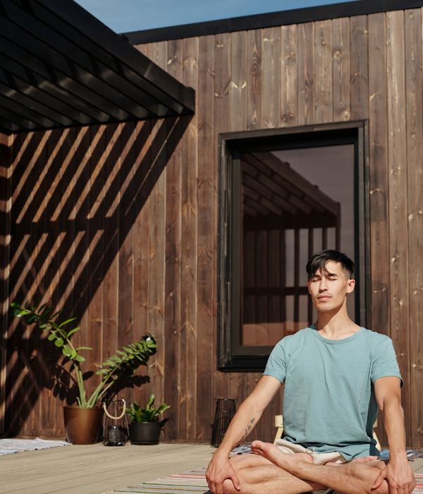Man meditating peacefully outdoors with a serene natural background.
